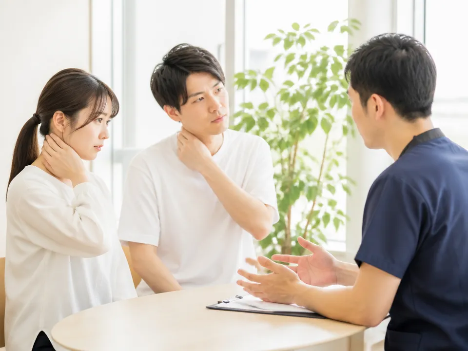 交通事故後の首の痛みを接骨院で相談する様子
