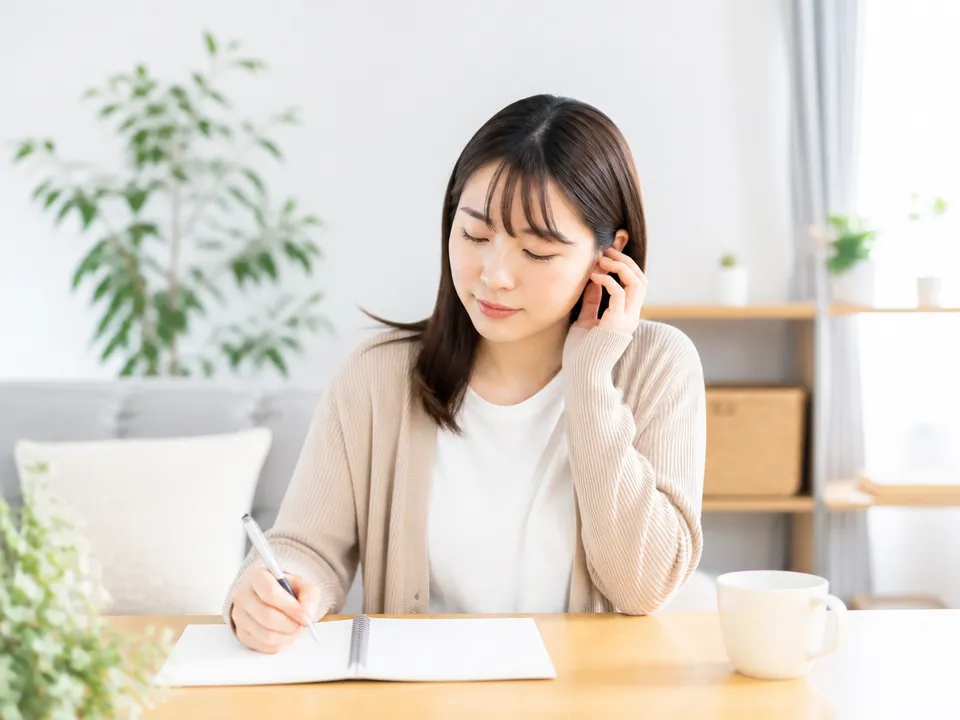 耳つぼセルフケアの記録をつけながら体調をチェックする様子