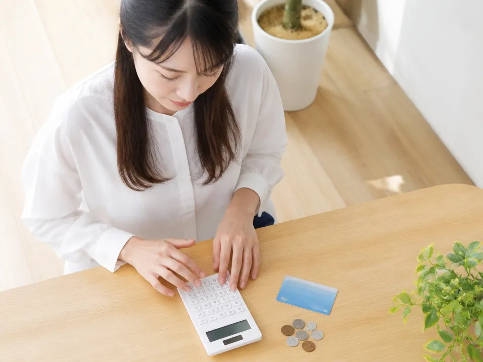 整骨院の料金イメージを電卓と保険証で確認している様子
