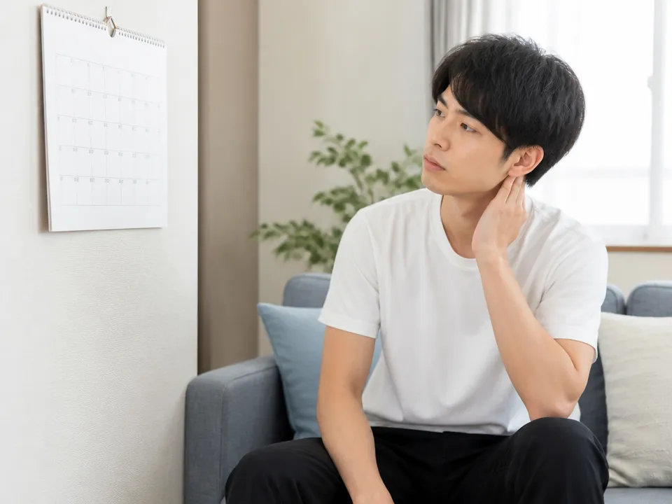 整骨院通いのやめどきに悩む男性がカレンダーを見ている様子