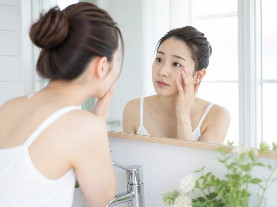 朝の支度中に目元のむくみを気にしている女性