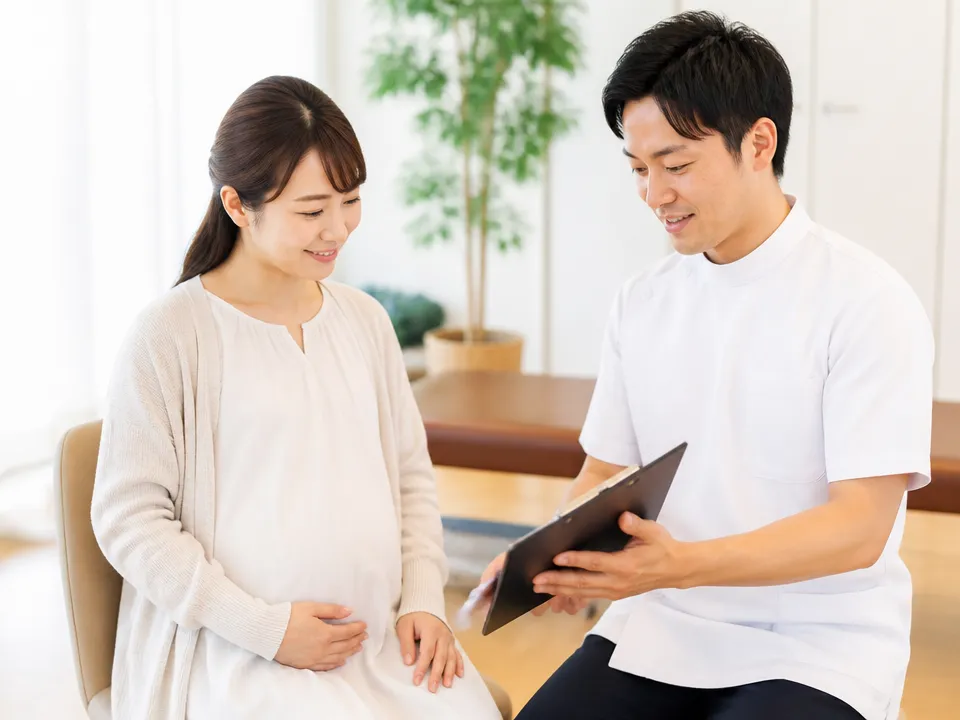 整体や整骨院でカウンセリングを受ける妊婦と施術者