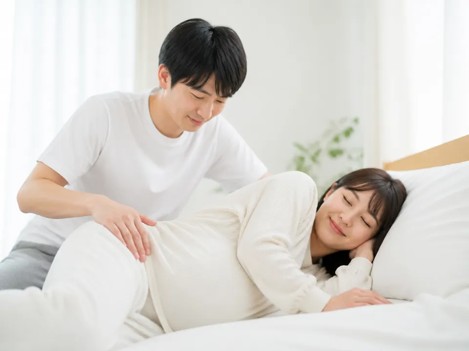 妊婦の腰を優しくマッサージする夫の手元