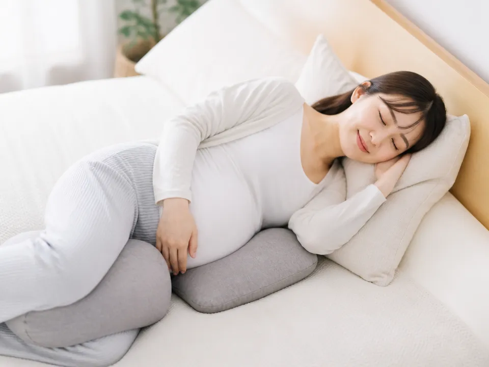 妊婦がクッションを使って横向きで楽な姿勢をとる様子