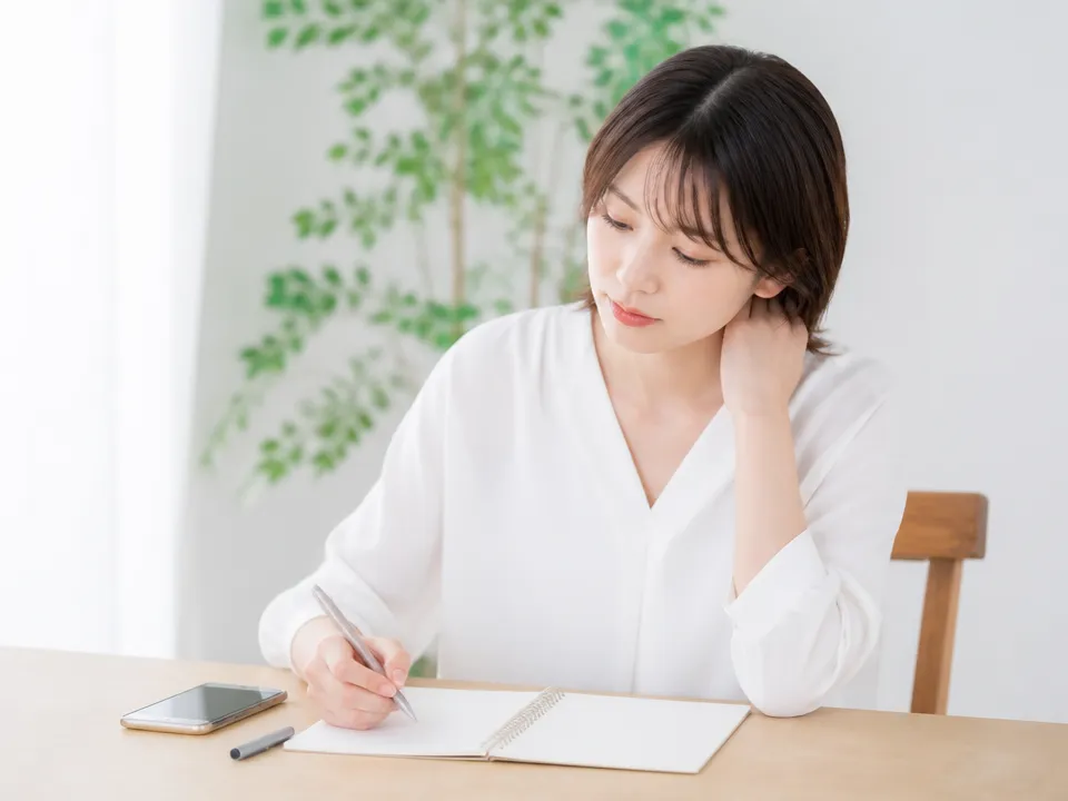 首や後頭部の不調とセルフケア内容をメモに整理している様子