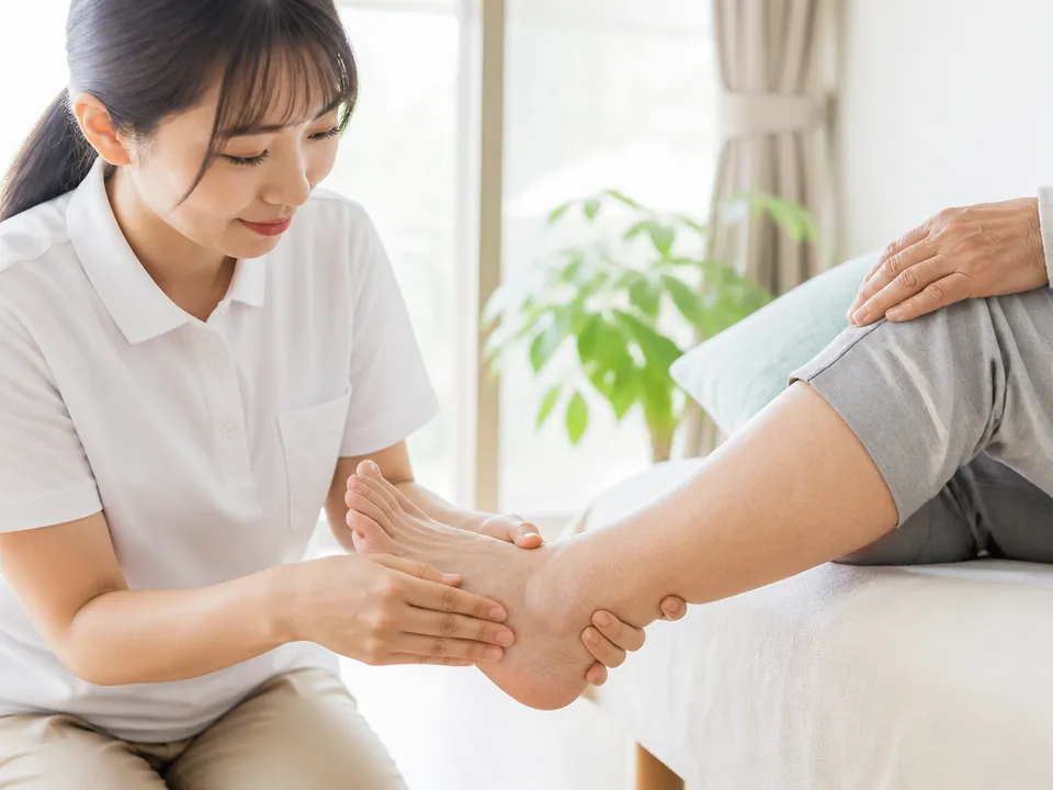 足の甲と足首・ふくらはぎを分けてやさしくマッサージする高齢者ケアの様子