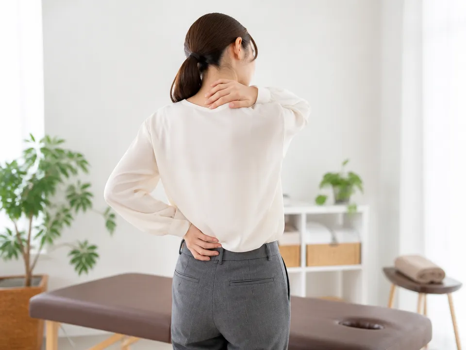 首から背中・腰にかけて広く凝りを感じている人のイメージ