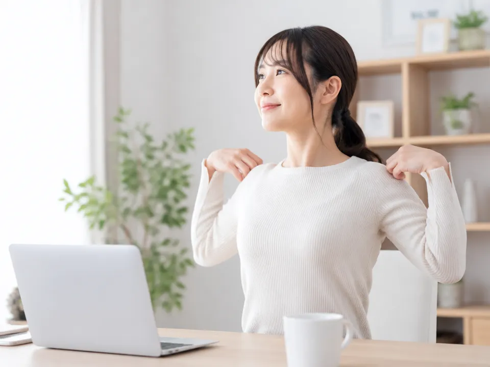 仕事中や家事の合間に姿勢を確認し肩の付け根のこりを予防する様子