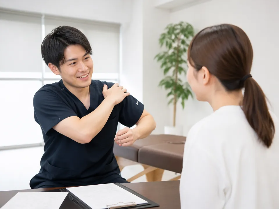 柔道整復師が肩こりの相談者にカウンセリングと運動指導を行う様子