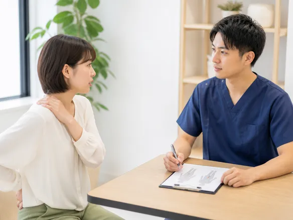 腰痛や肩こりなど複数の症状をカウンセリングで相談している場面