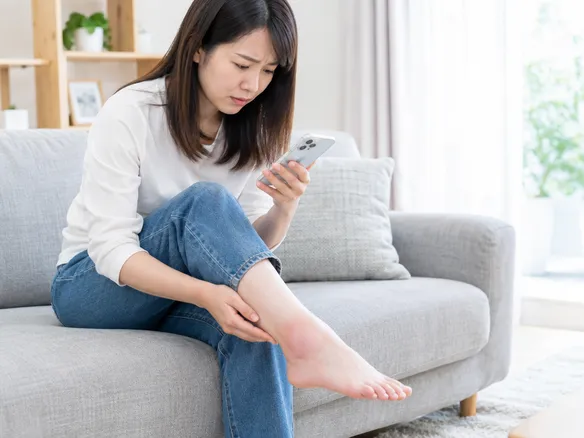 足関節捻挫と骨折の違いに悩み足首を見つめる人