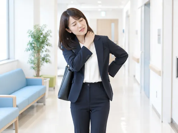 首や肩こりとともに頭痛や腰痛も抱える人のイメージ