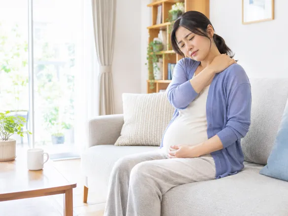 妊娠中の姿勢変化で肩こりに悩む女性のイメージ