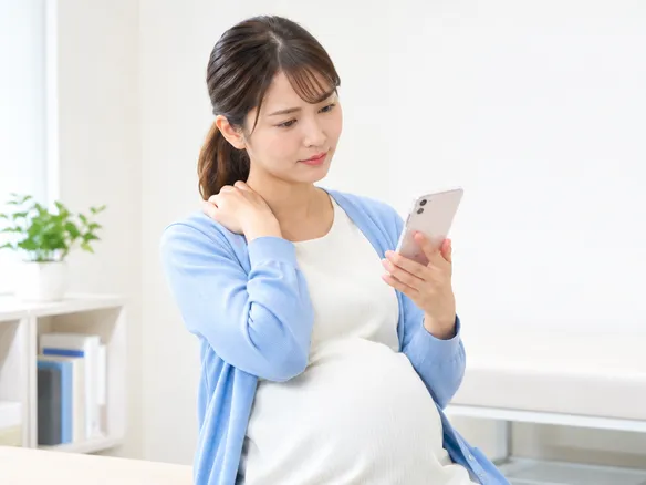 肩こりマッサージを受けるか迷う妊婦のイメージ