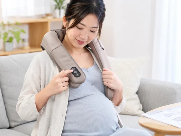 妊娠中にマッサージクッションの強さ設定を確認する女性