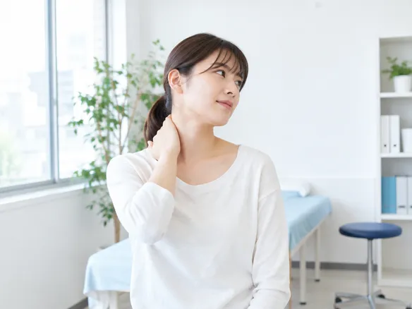 首の付け根の張りや痛みを感じている人が動きを確認している様子
