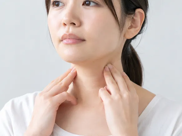首の付け根のコリコリやしこり感を指でそっと触って確認する様子