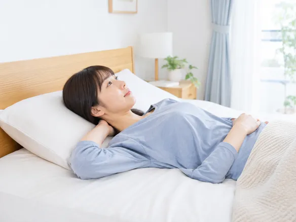 枕と寝姿勢を見直している人が首の角度を確かめている様子