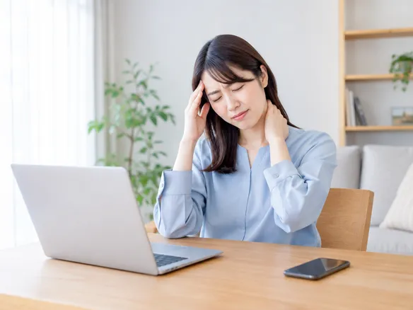 首こりと肩こりに頭痛と吐き気が重なりつらそうにしている人