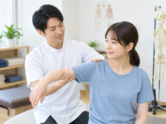 中村接骨院で柔道整復師の院長が説明しながら施術を行う様子