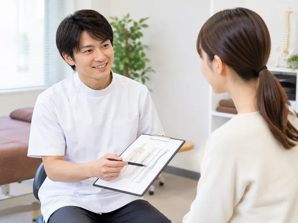 柔道整復師の院長がカウンセリングと施術プランを説明する様子