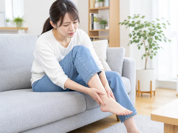 くるぶしの下の痛みで受診を迷っている人のイメージ写真