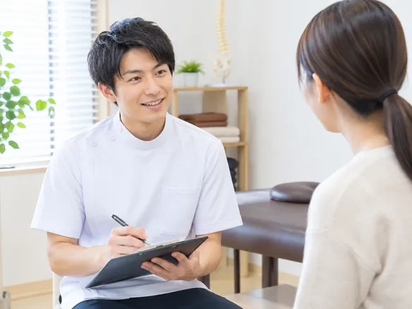 接骨院でカウンセリングを行う院長と患者
