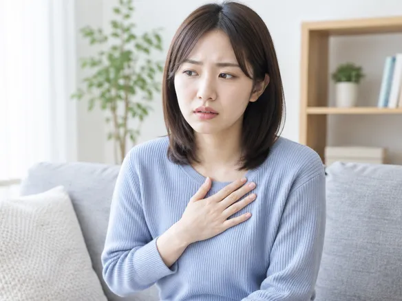禁煙後のイライラや不安感、動悸に悩む人が胸に手を当てている様子
