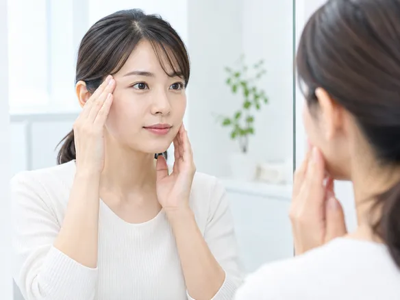 こめかみやあご周辺を指で触れて場所を確認する様子