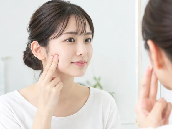 咬筋の位置を頬に指を当ててセルフマッサージする様子