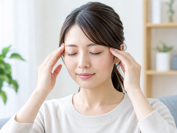 こめかみから耳の上の側頭筋を軽くマッサージする様子
